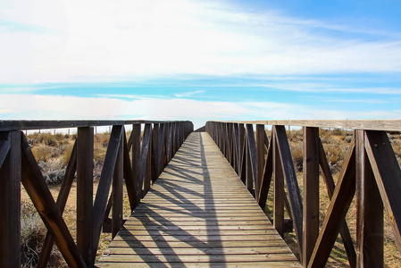 在沙丘上的木制人行道上的海滩。韦尔瓦海滩的海滨通道, 位于西班牙安大路西亚的自然区域内。