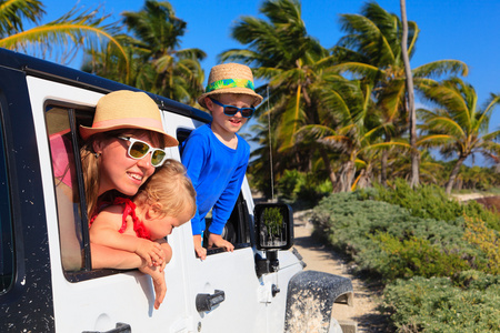 家庭在热带海滩上驾驶越野汽车