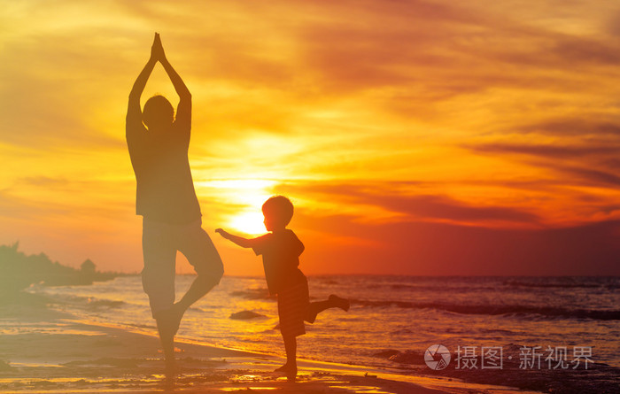 父亲和儿子做瑜伽海上日落