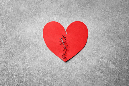 男人拿着两半红纸的心, 而女孩却把他推开了.