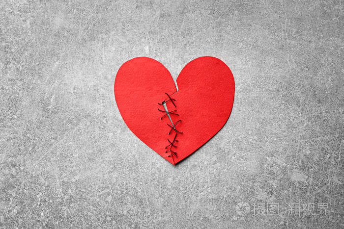 纸心切成两半在光背景下缝合在一起关系问题