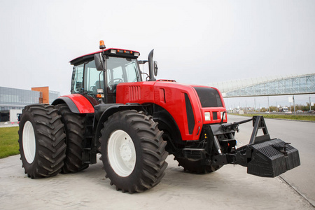 新的红色现代化农用拖拉机与大轮子在露天陈列