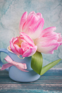 粉红色郁金香花在蓝色杯子里