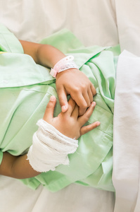 医院里的一个小女孩病人肿胀和绷带的手