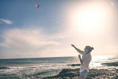美丽的年轻女子女孩在海边放风筝