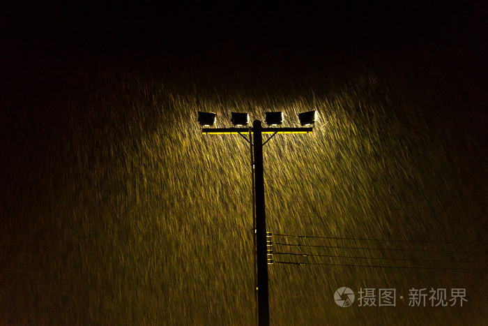 松软的夜晚路灯亮在大雨暴雨粒度图像中的