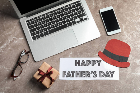 智能手机, 笔记本电脑, 礼品盒和贺卡, 生日快乐父亲节在灰色背景, 顶部视图