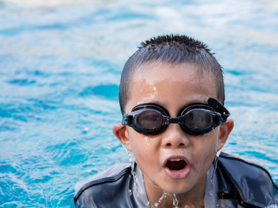 小亚洲男孩在游泳衣尝试呼吸