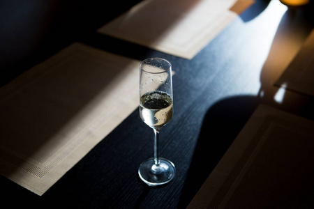 一杯香槟 shitoit 在夕阳下的一张漆黑的木桌上