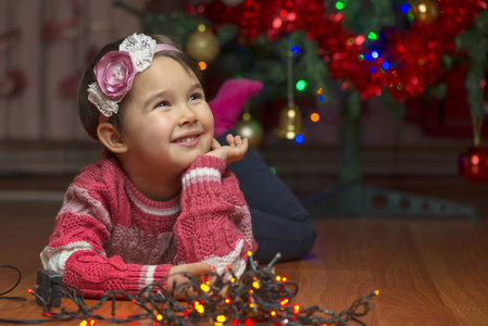 可爱的小女孩与圣诞树背景上的肖像