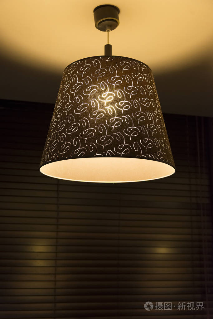 百叶窗背景上悬挂的天花板灯