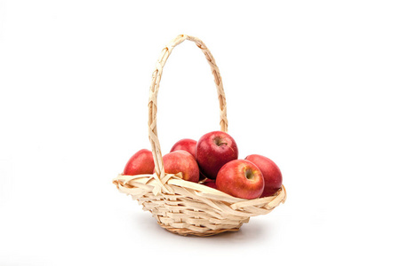 红色苹果在柳条篮子隔绝在白色