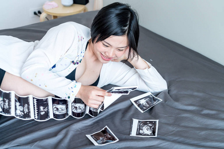 年轻美丽的亚洲孕妇与超声胶片