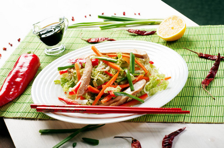 明亮的多汁饮食凉拌卷心菜 红辣椒 胡萝卜 葱 和烤鸡在白板上。东部，中国菜。简单的自制沙拉饮食