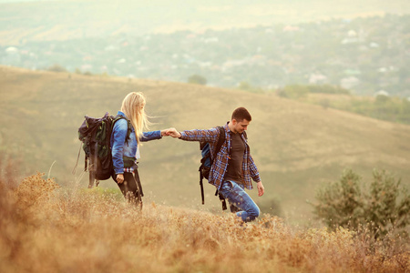 一对带着背包的年轻夫妇在大自然中漫步
