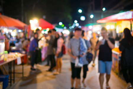 人们走在街头夜市的模糊画面