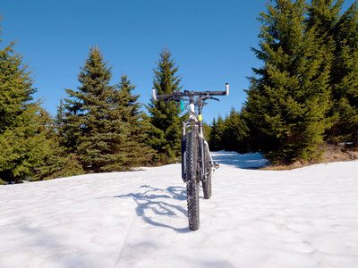 山地自行车在雪地里。在雪地上骑着大轮胎骑车