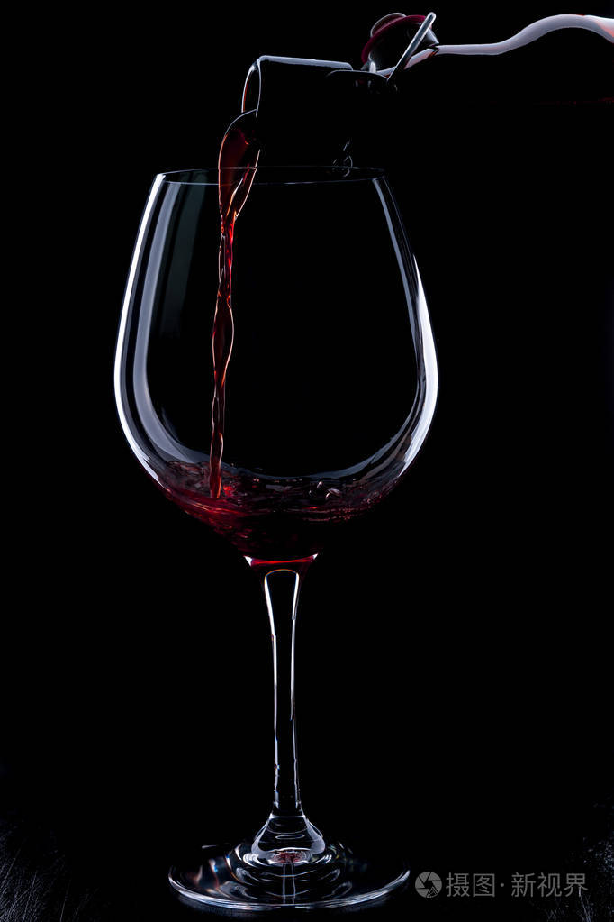 红酒倒入酒杯黑色背景上孤立