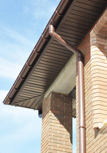 房子屋面雨天沟排水管道落水管安装未完成的房子外墙砖墙上在户外.