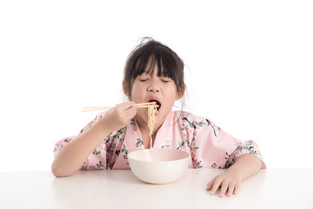 小的亚洲女孩穿和服和吃面条照片