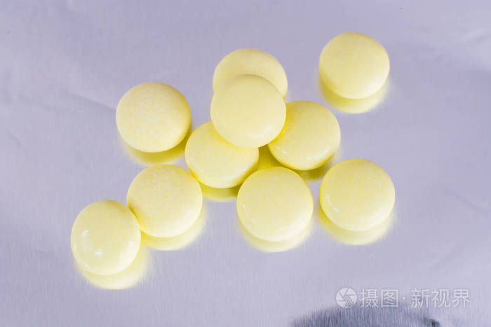 箔背景上孤立的药学主题黄色成药片剂