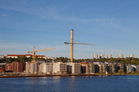 现代高层建筑沿着海岸与建筑起重机在施工的最后阶段