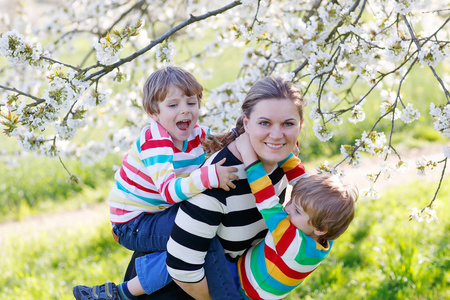 年轻的母亲和两个小双胞胎男孩开心中盛开的遗传算法