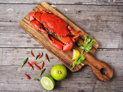 在桌上的木板上的新鲜的螃蟹与香料的顶部视图