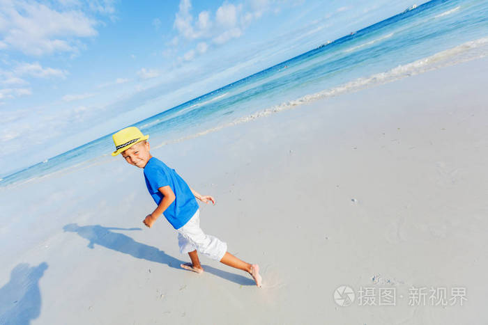 在热带海洋沙滩上玩耍的男孩.孩子在家庭海度假期间