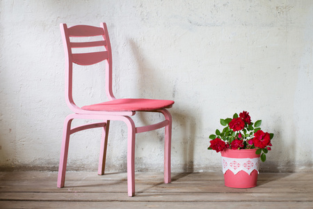 玫瑰背景 grunge 墙上的旧椅子上