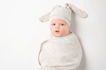 可爱的新生婴儿在茧和滑稽的帽子在白色背景