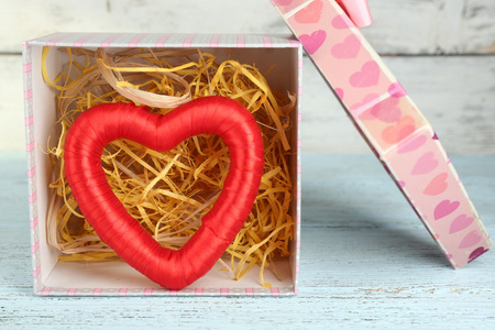 红色的心，在礼物盒木制的桌子上