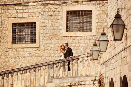 新郎和新娘接吻在旧城的楼梯上