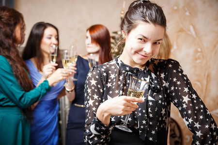美丽的年轻女子，与杯香槟庆祝新的一年，与朋友的画像