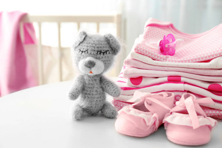 针织玩具熊和婴儿衣服在桌上