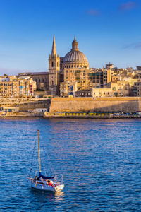 瓦莱塔，马耳他圣保罗大教堂在黄金时段在马耳他首都瓦莱塔与帆船和美丽的蓝天