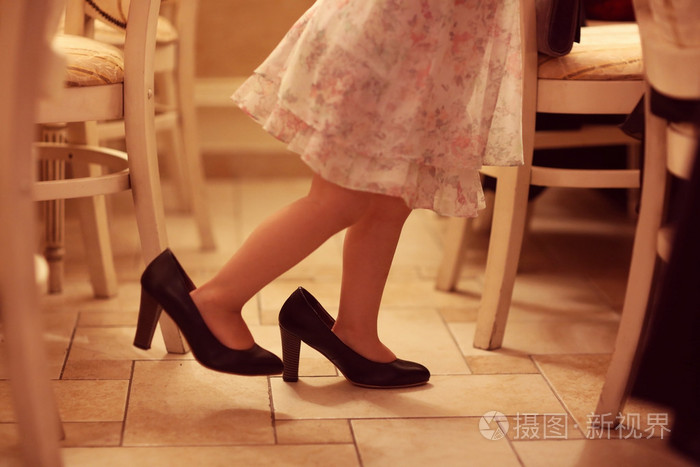 一个母亲穿鞋玩耍的女孩的双腿