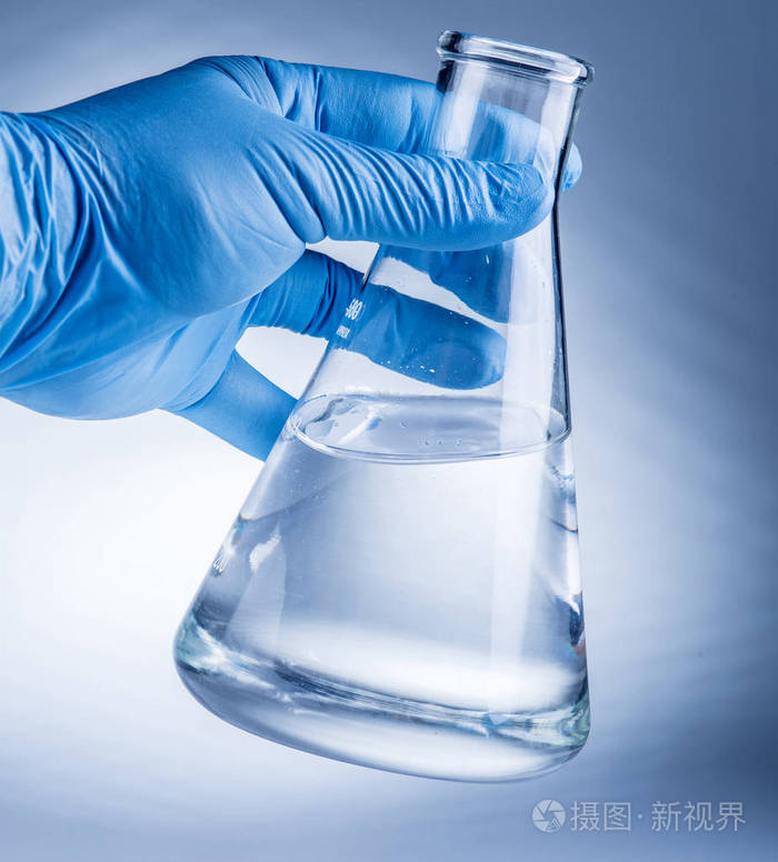 在分析师的手中塑料手套实验室烧杯
