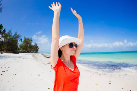 幸福的女人，戴着帽子在热带的海滩上享受她的假期