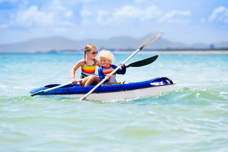 儿童在热带海皮划艇照片