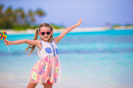 可爱的小女孩，用棒棒糖热带海滩度假