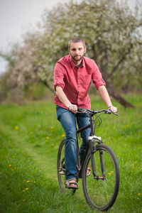 胡子骑一辆自行车的年轻男人