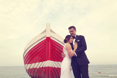新娘和新郎附近大，红色的小船，在大海