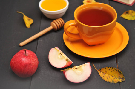 秋季静物杯茶，蜂蜜和桌子上的书