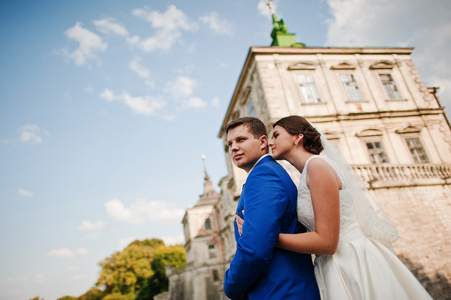 年轻的新婚夫妇在背景的老城堡