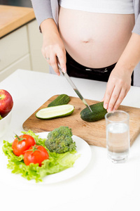 孕妇在厨房做蔬菜沙拉的特写照片