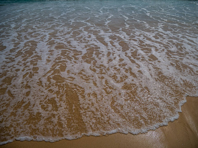 美丽的安达曼海海岸线，强烈海浪在海边与泡沫清洁黄沙，完美的电影，数字组成