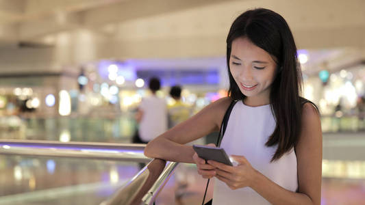 女人在购物商场中使用手机