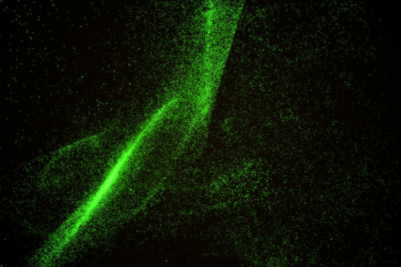 由绿色发光粒子的抽象背景