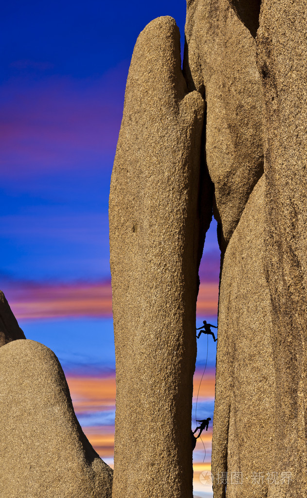陡峭的悬崖上的登山者斗争的团队